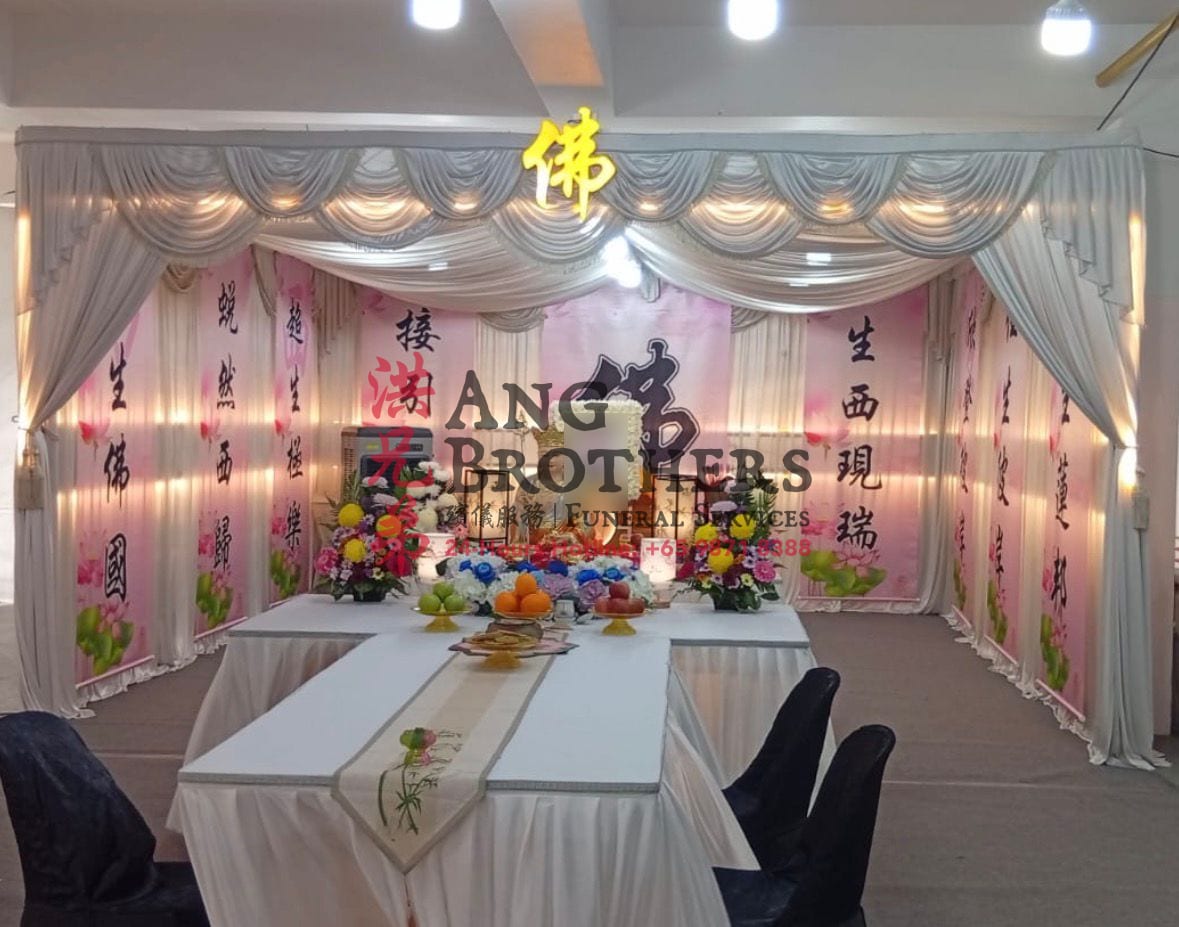 A pink lotus Buddhist setting with a gold Buddha and calligraphy banners