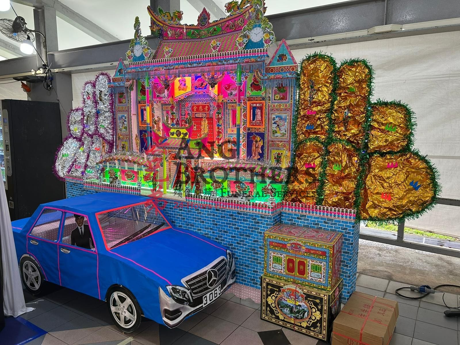 Paper mansion with a paper motorcar and gold offerings