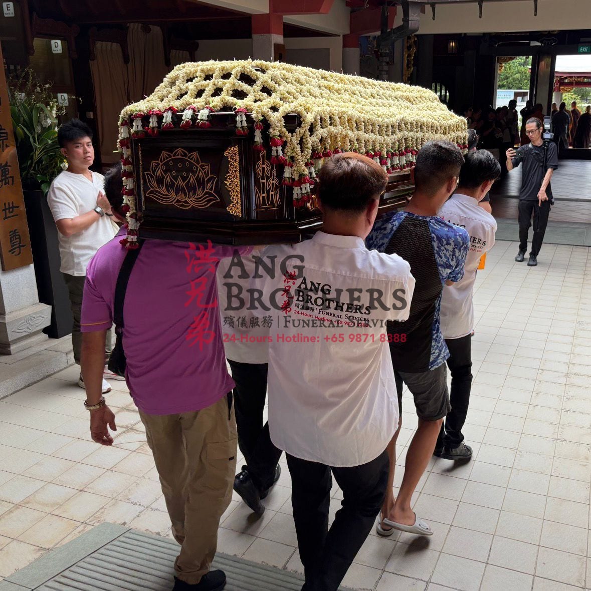 A garlanded casket carried out for the final send off at a temple