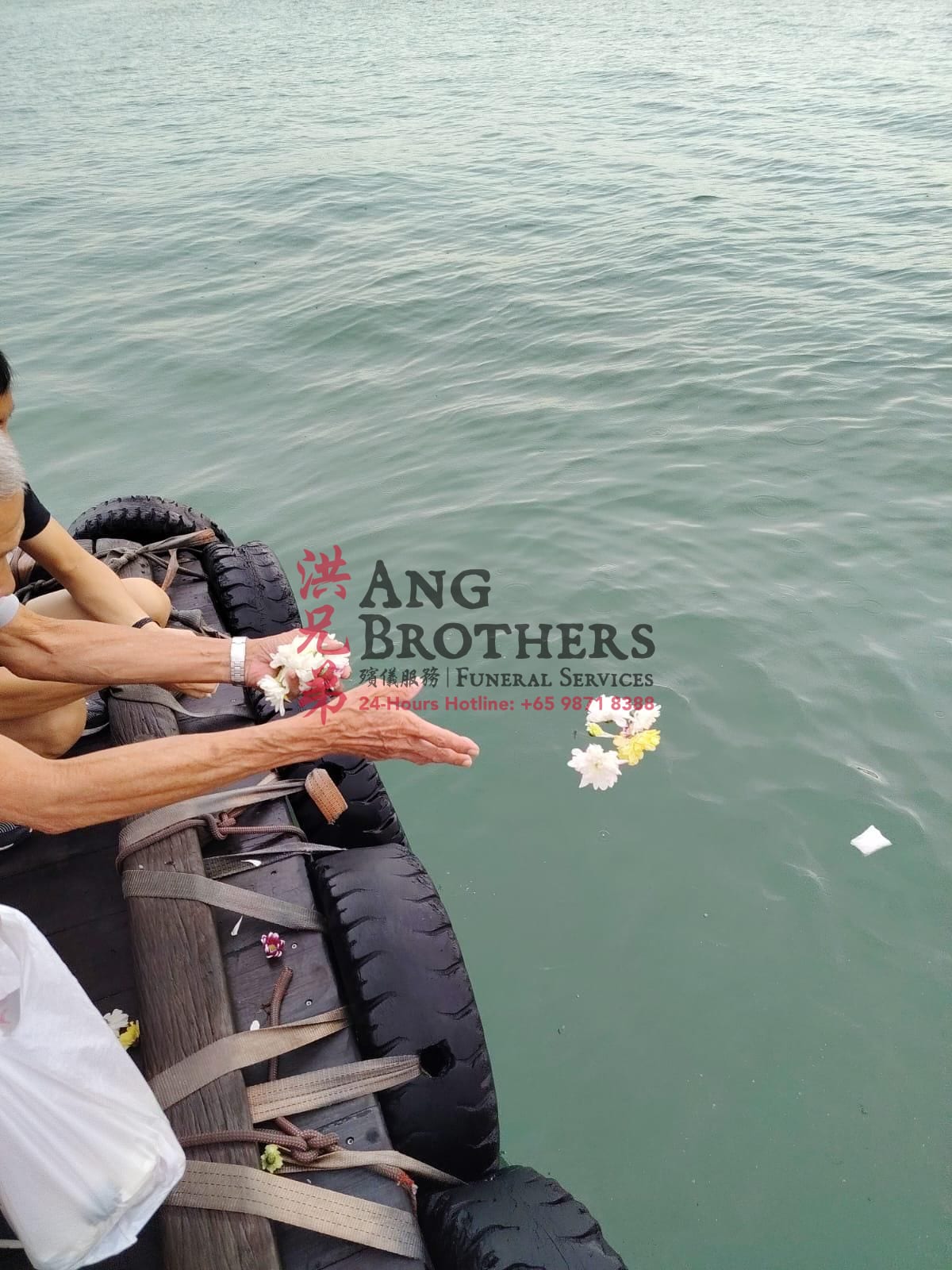 Hands releasing fresh flowers into the sea