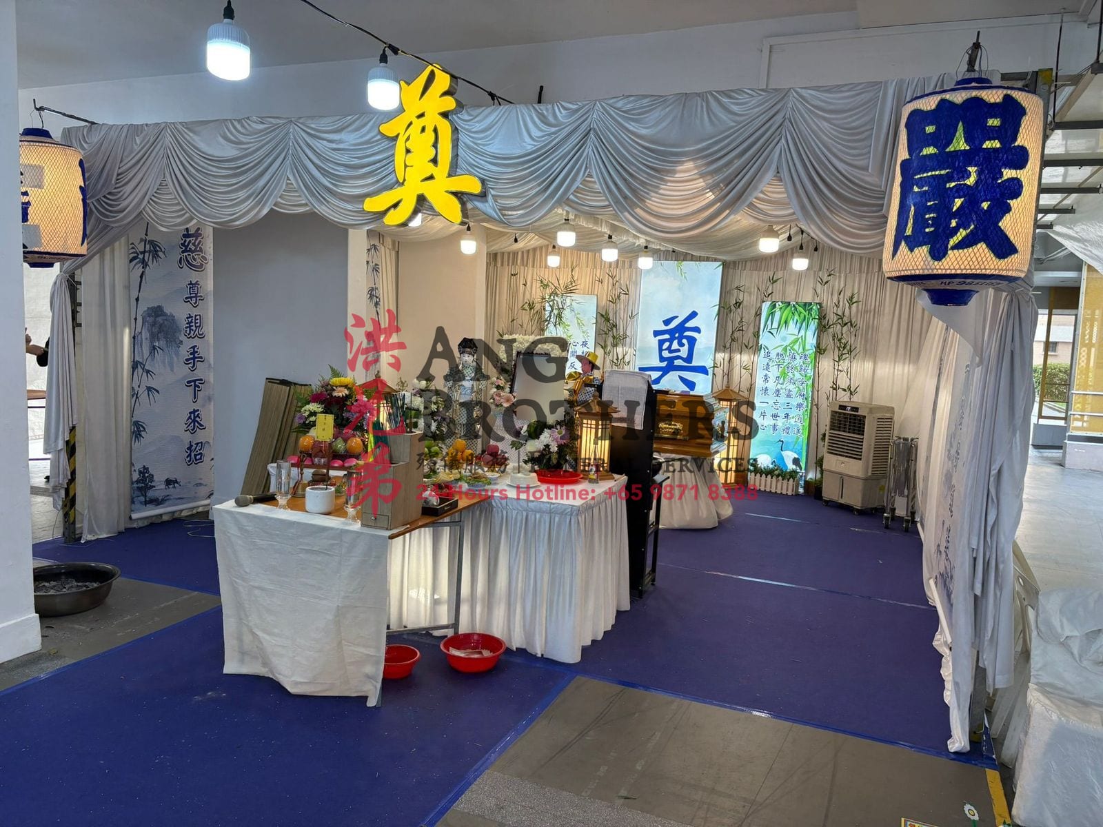 A Taoist wake with a deity statue beneath the gold character of mourning